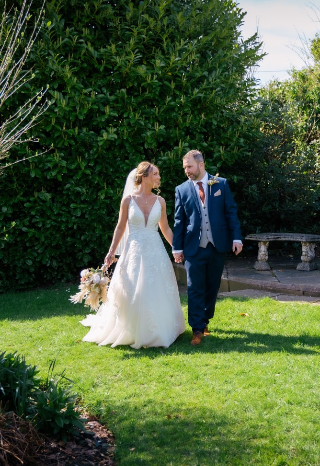 bride and groom walking through the grounds at Shireburn Arms 