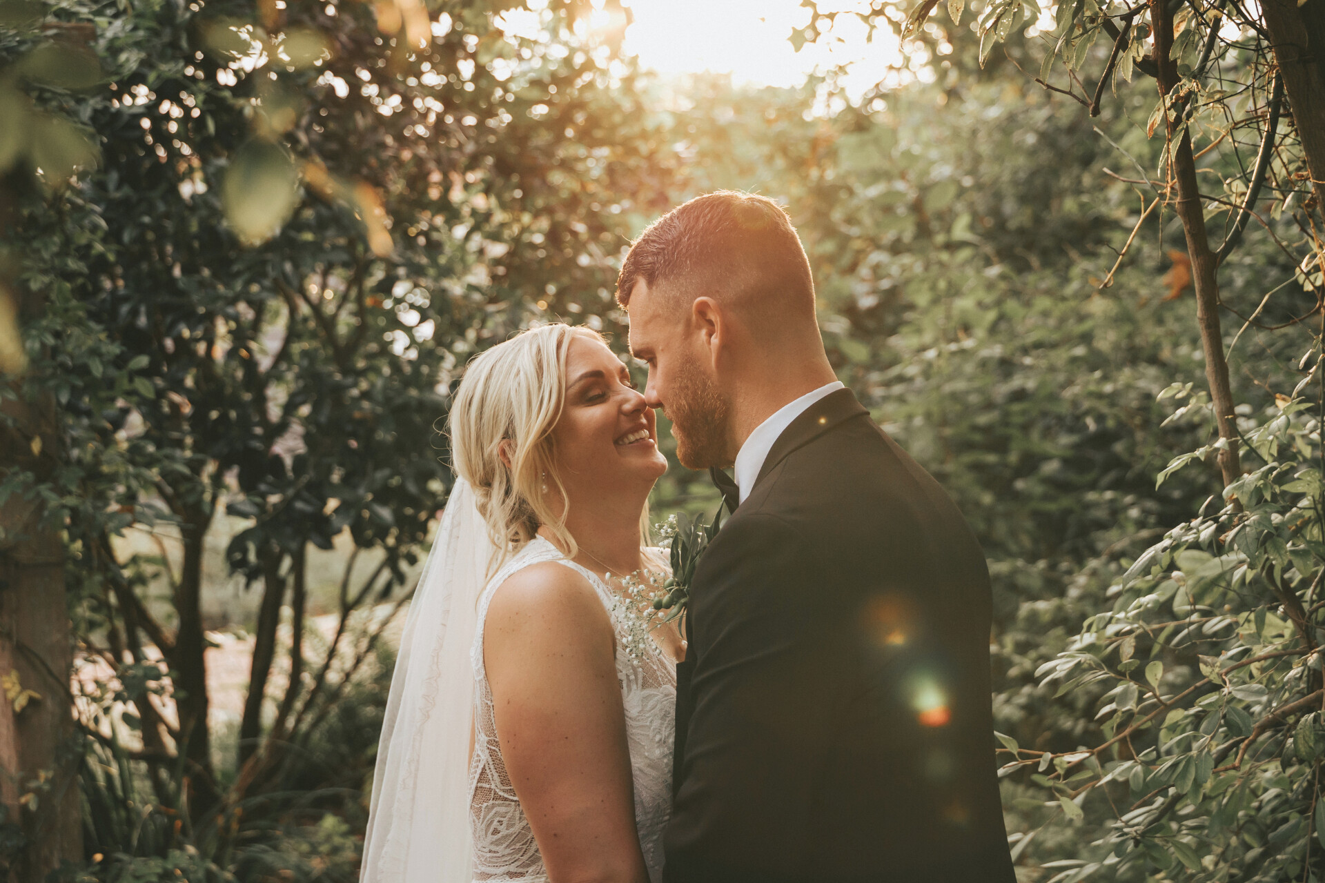 Couple enjoying golden hour wedding portraits in the gardens at Alfriston Gardens wedding venue in East Sussex.