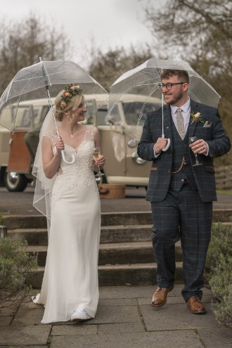 bride and groom sipping champagne in the rain