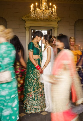 Ana and Satveer stood in the middle of the room while their guests run circles around them.