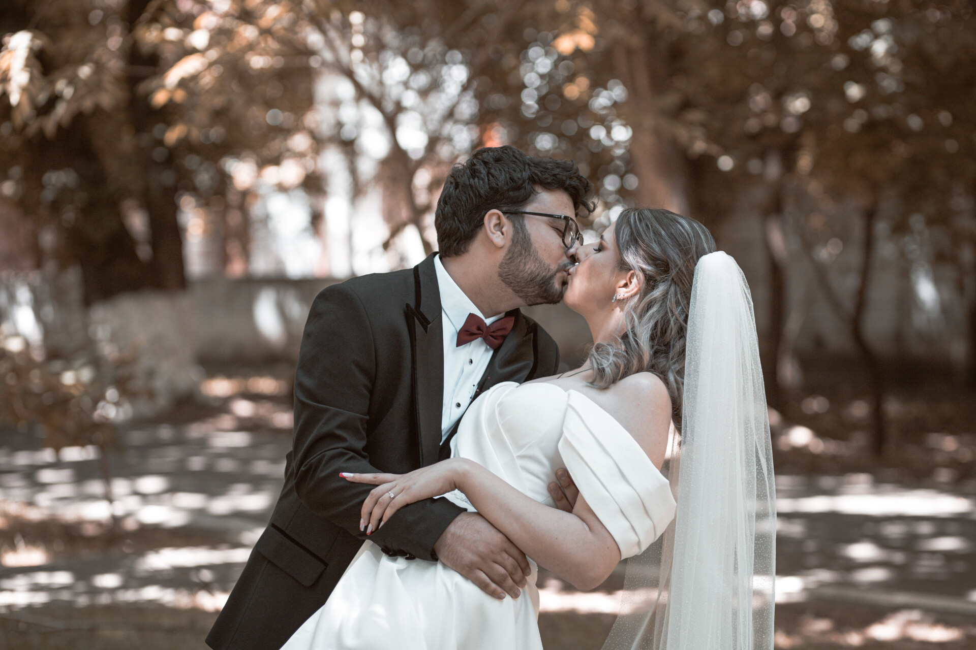 Bride and groom sharing a kiss during a wedding portrait in a woodland setting