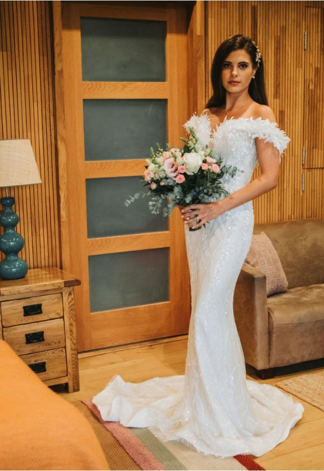 Bride posing in the lodge beside the bed