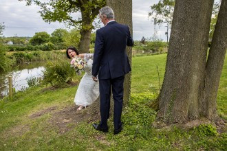 bride and groom playing hide and seek