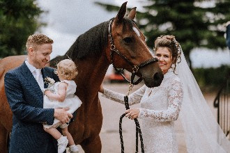 The Bride and groom with their child and horse