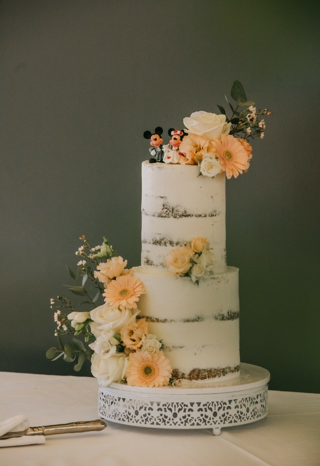 Two tiered, white and floral Disney wedding cake 