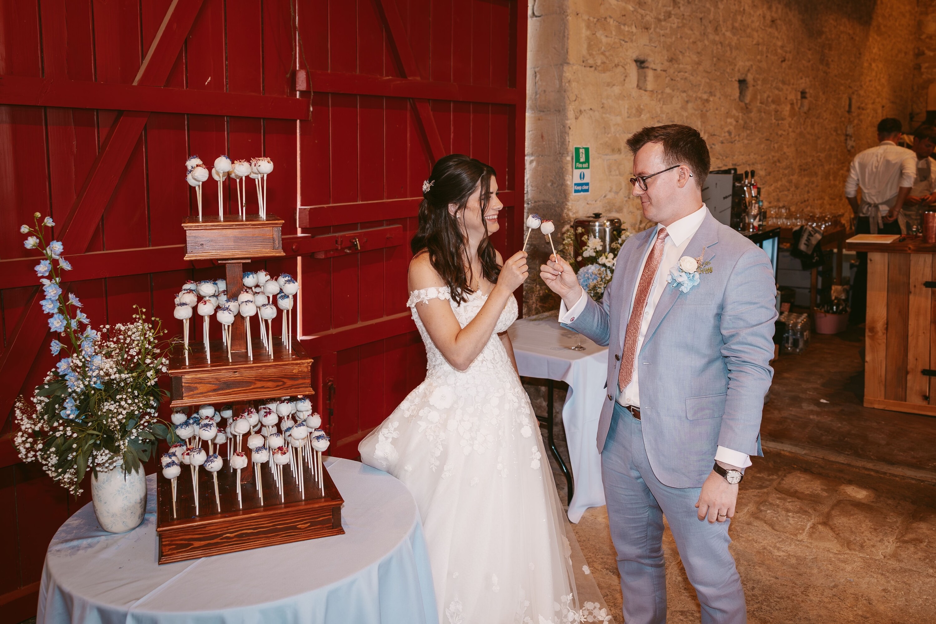 Wedding reception at Cogges Manor Farm showing the wedding cake pops and the bride and groom
