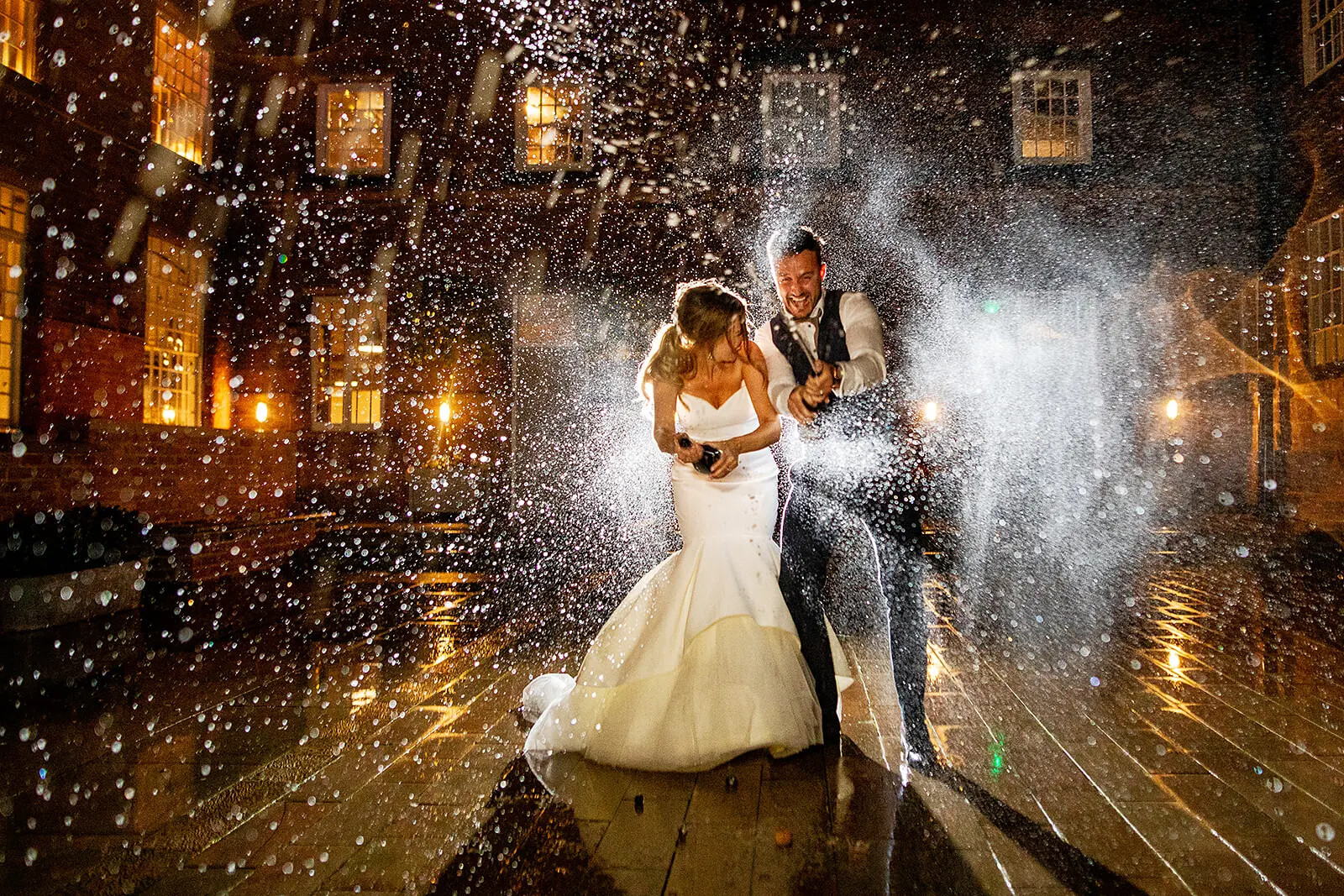 Wedding couple champagne spray moment captured by Everybody Smile Photography, Oxfordshire.
