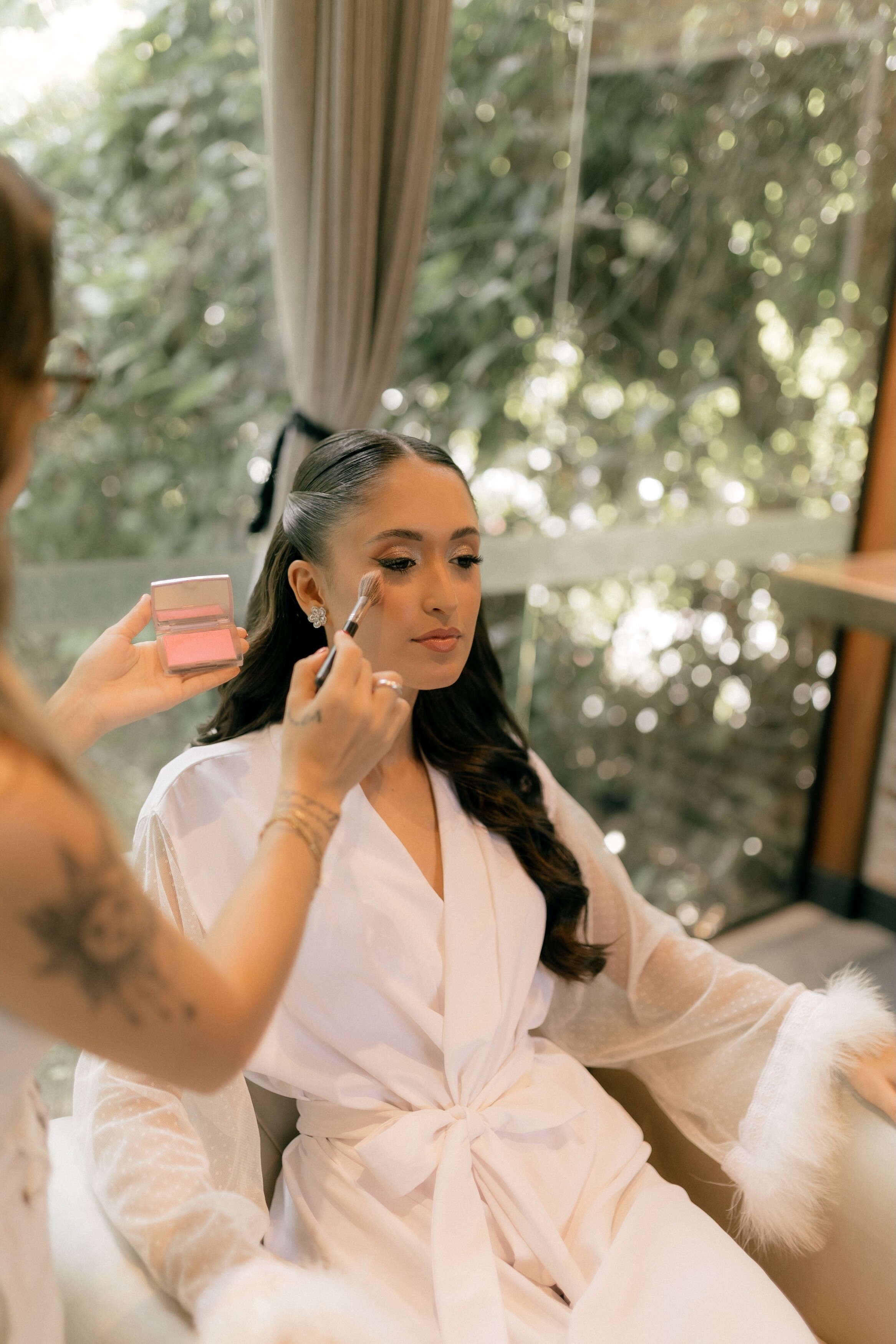 Bride having makeup done on wedding day