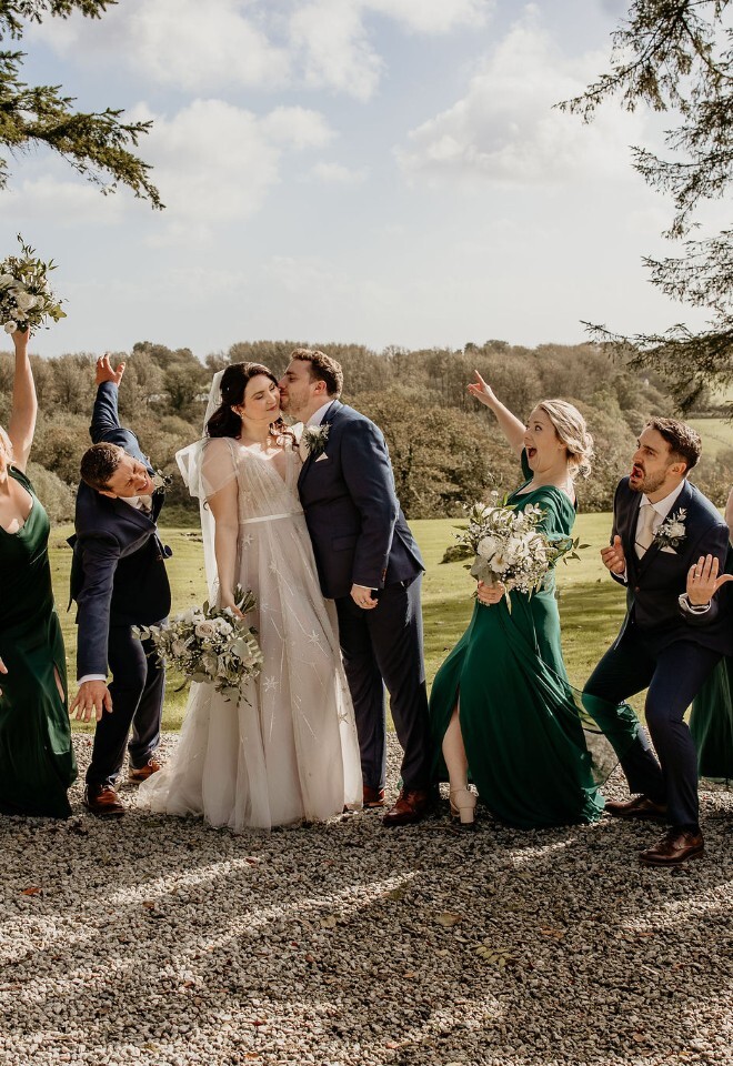Fun wedding party group shot with bride and groom outdoors.