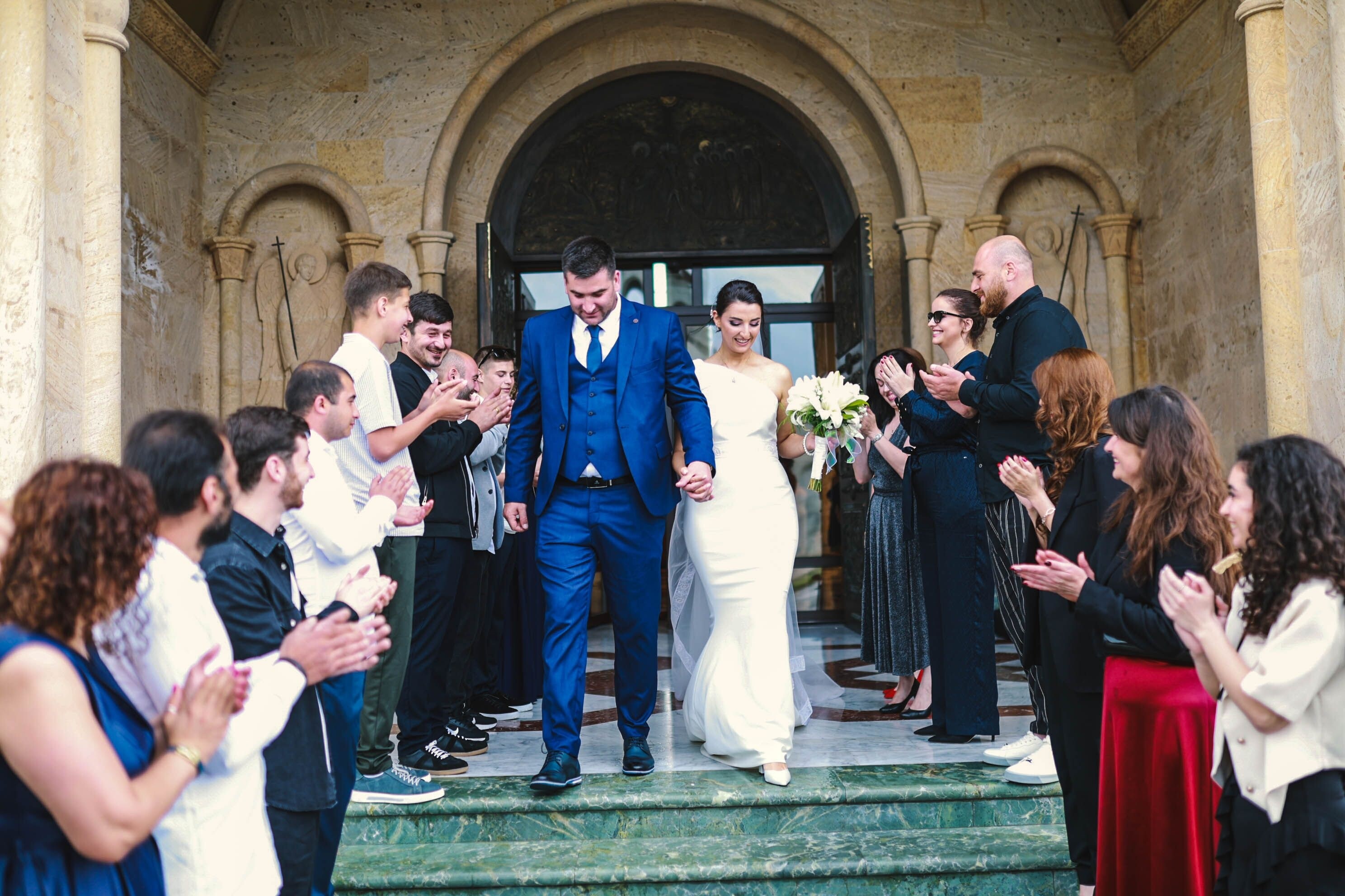 Bride and groom exit wedding ceremony. Guests are clapping. 
