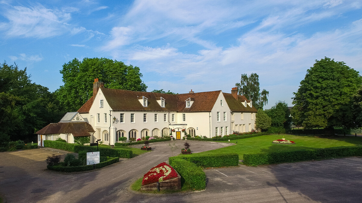 Exterior of Ware Priory in Hertfordshire, showing the historic riverside building set within landscaped gardens