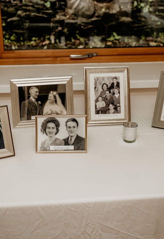 Display of framed family wedding photos on a reception table.