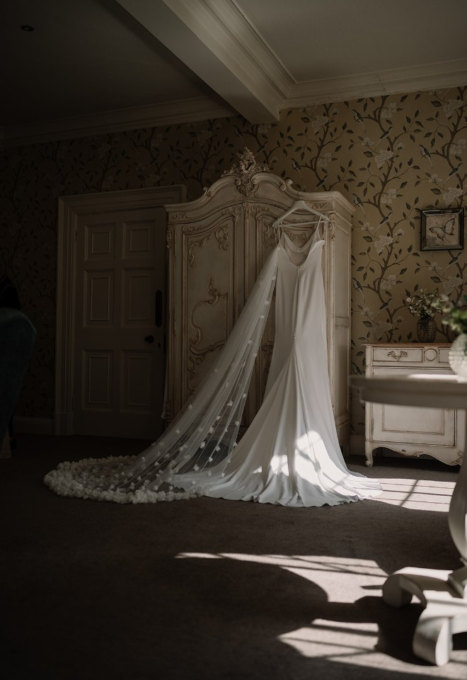 Annabelles wedding dress hanging from dresser