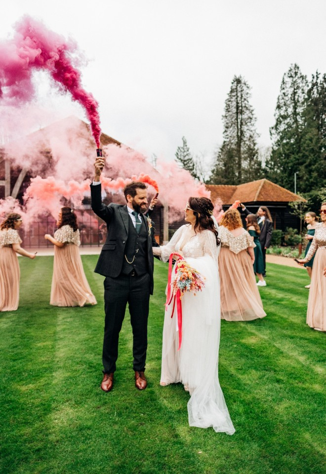 Bride and groom with pink smoke