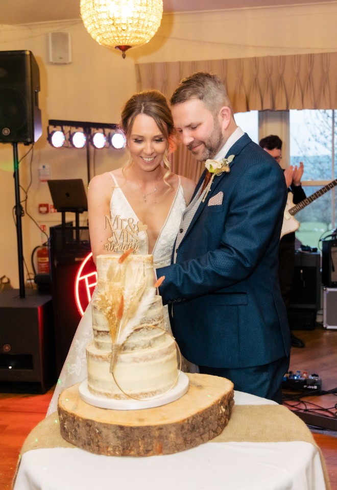 bride and groom cutting their wedding cake 