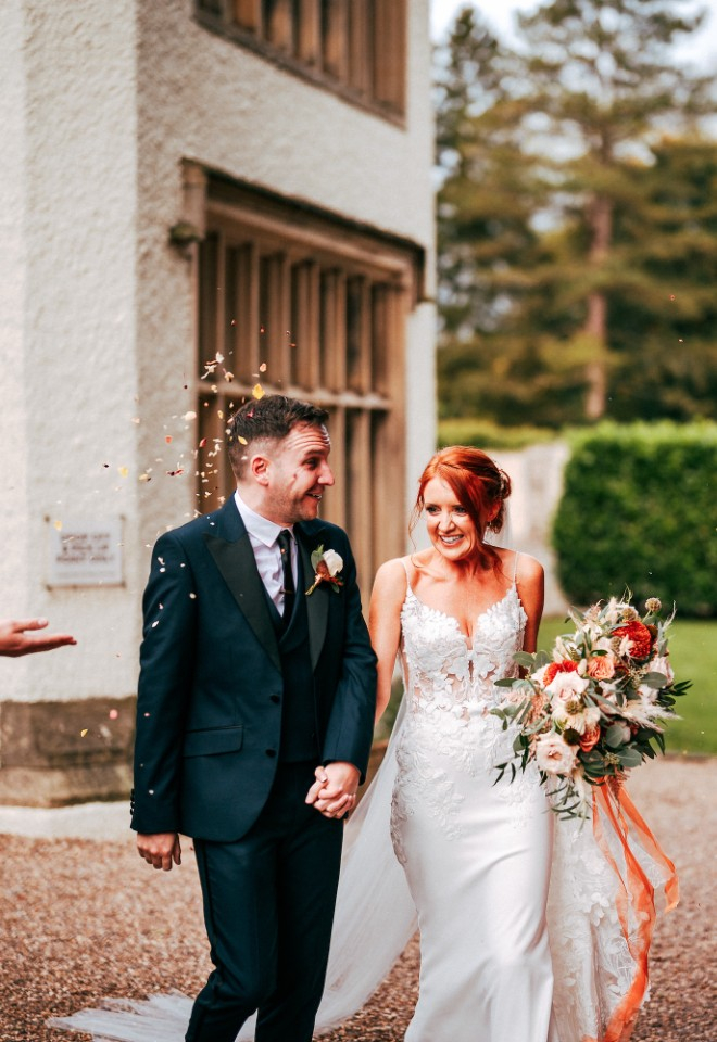 Wedding guests throwing confetti at the bride and groom