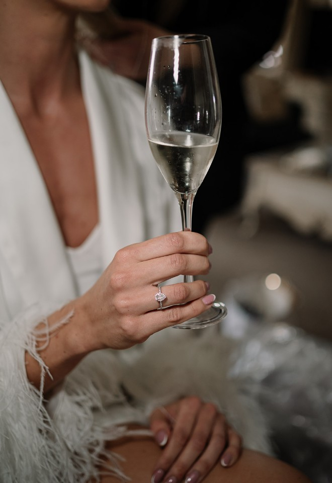 Bride holds champagne on wedding morning