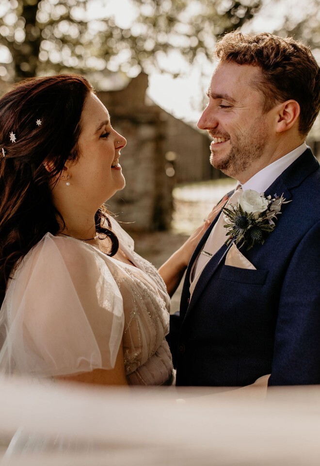 couple getting married, looking into each others eyes with a rural setting in the background