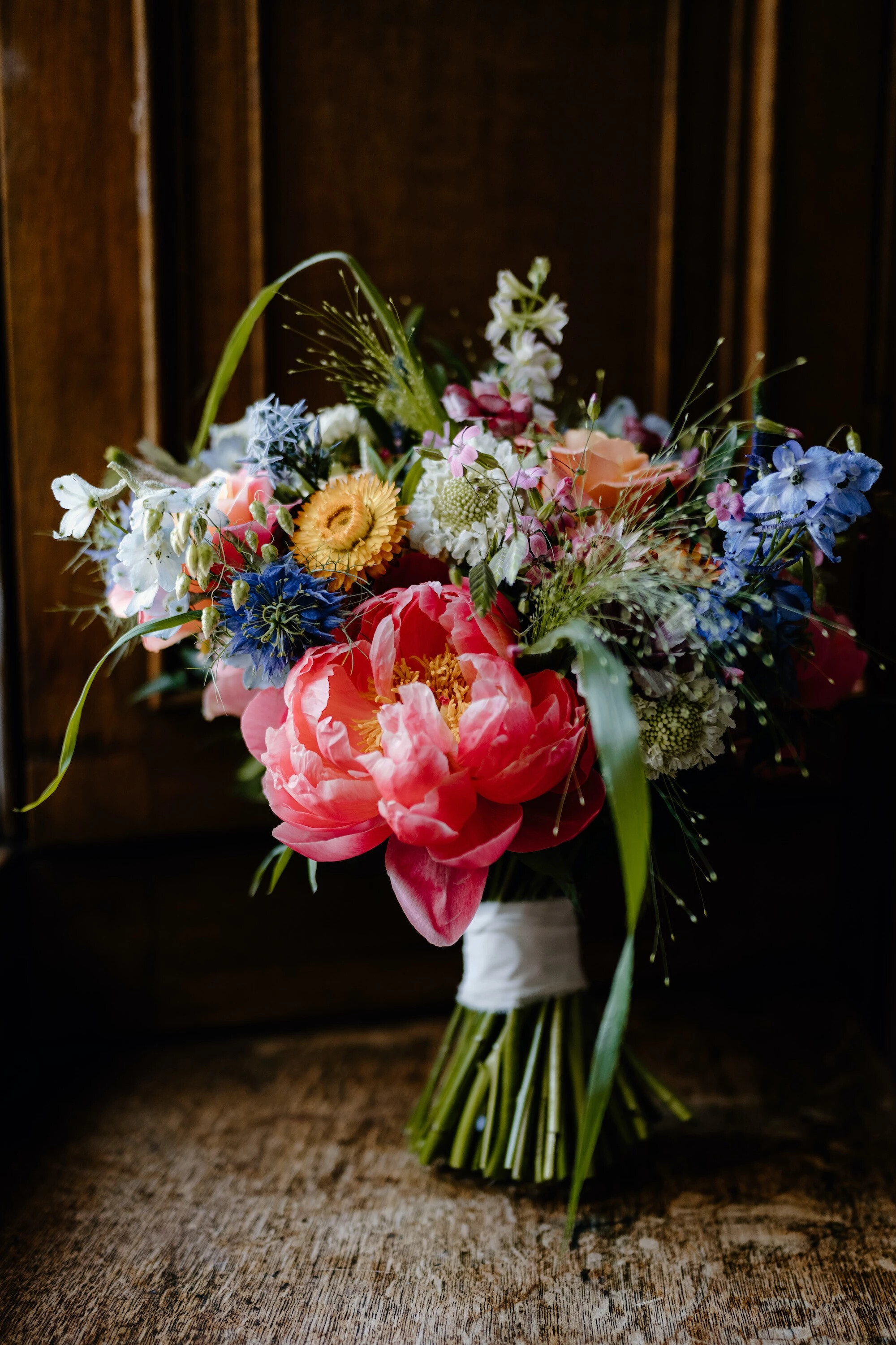 Bold and colourful wedding bouquet with pink, yellow, blue and orange flowers