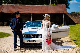 Bride and groom in front of Ford Mustang