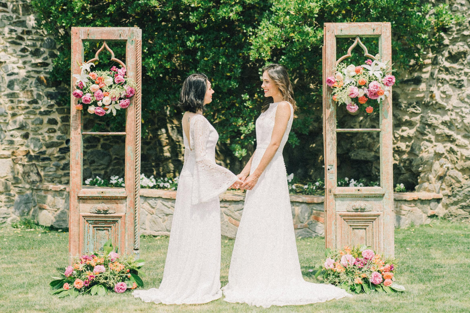 Bride and bride couple holding hands during an outdoor same-sex wedding ceremony