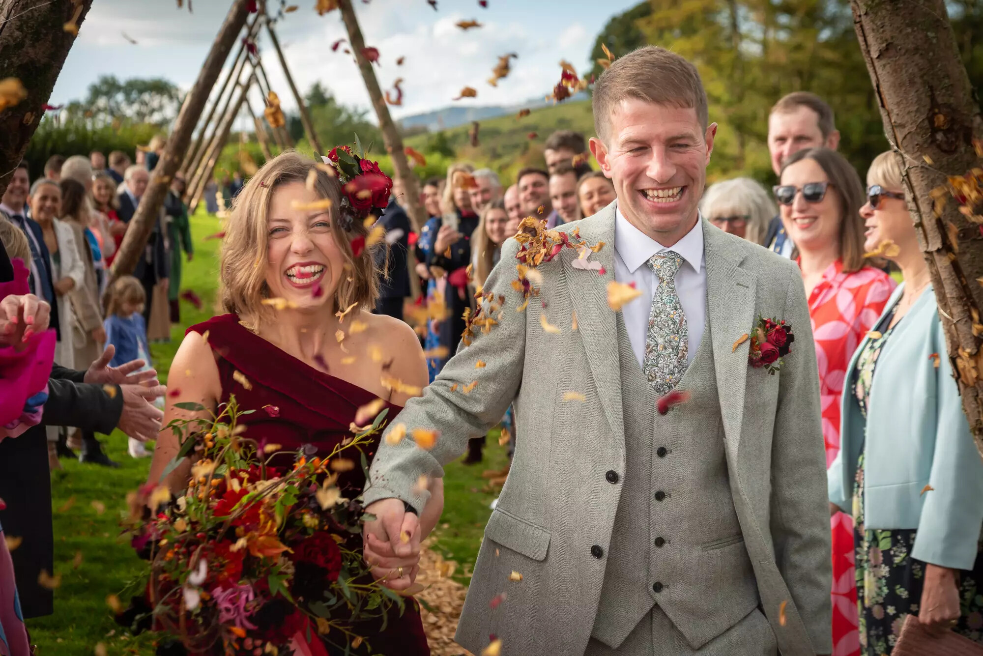 Wedding couple confetti moment, with autumnal orange/brown confetti. Taken by Martin Carter Photography, Dorset