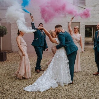 bride, groom and bridal party with coloured smoke