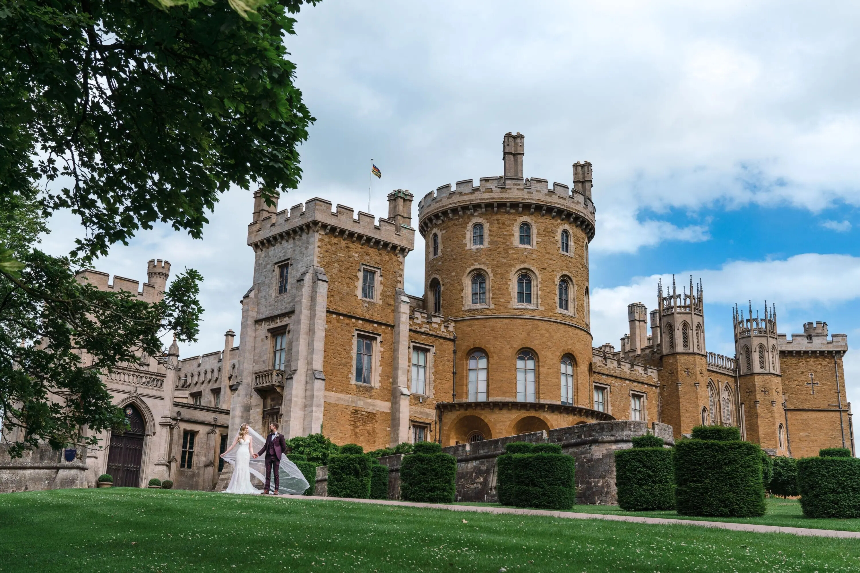 Bride and groom standing outside Belvoir Castle