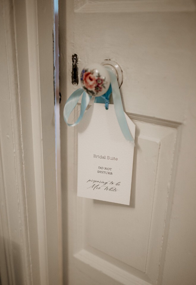 Bridal suite door with a “Do Not Disturb” sign tied with a blue ribbon.