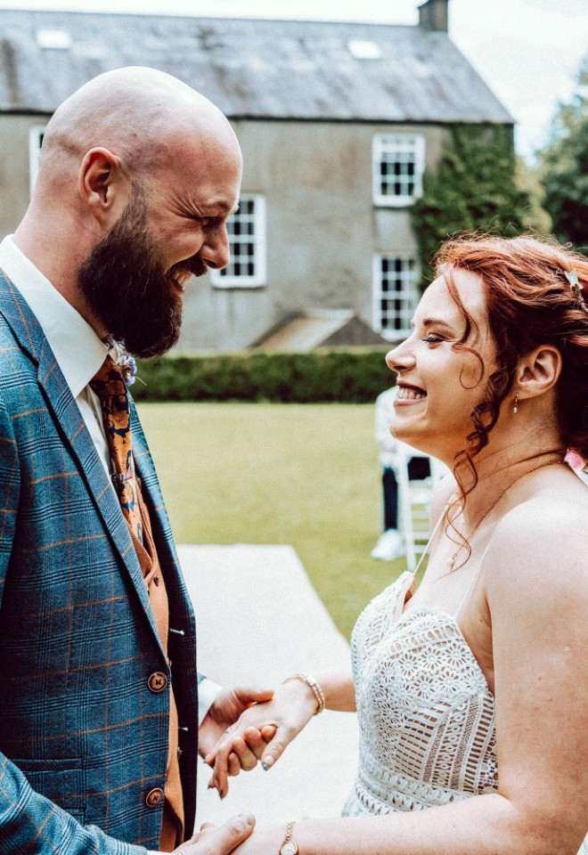 Bride and groom smiling at the top of the aisle