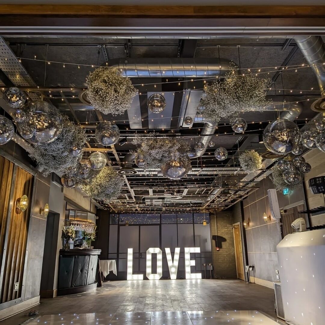 Wedding party space set up with lights, dancefloor and LED love sign at The Royal Foresters, Berkshire.
