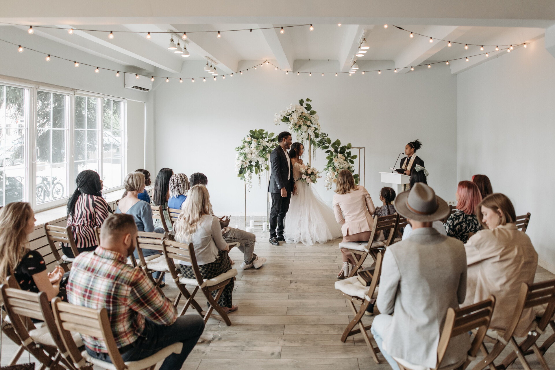 Couple exchanging vows during an intimate indoor wedding ceremony with family and friends
