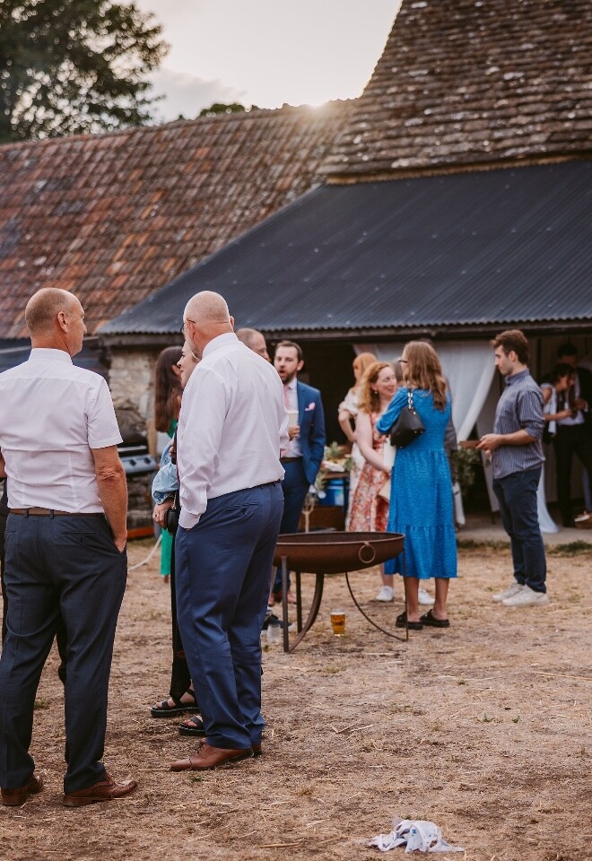 Guests congregating outside the barn at Cogges Manor Farm Wedding Venue