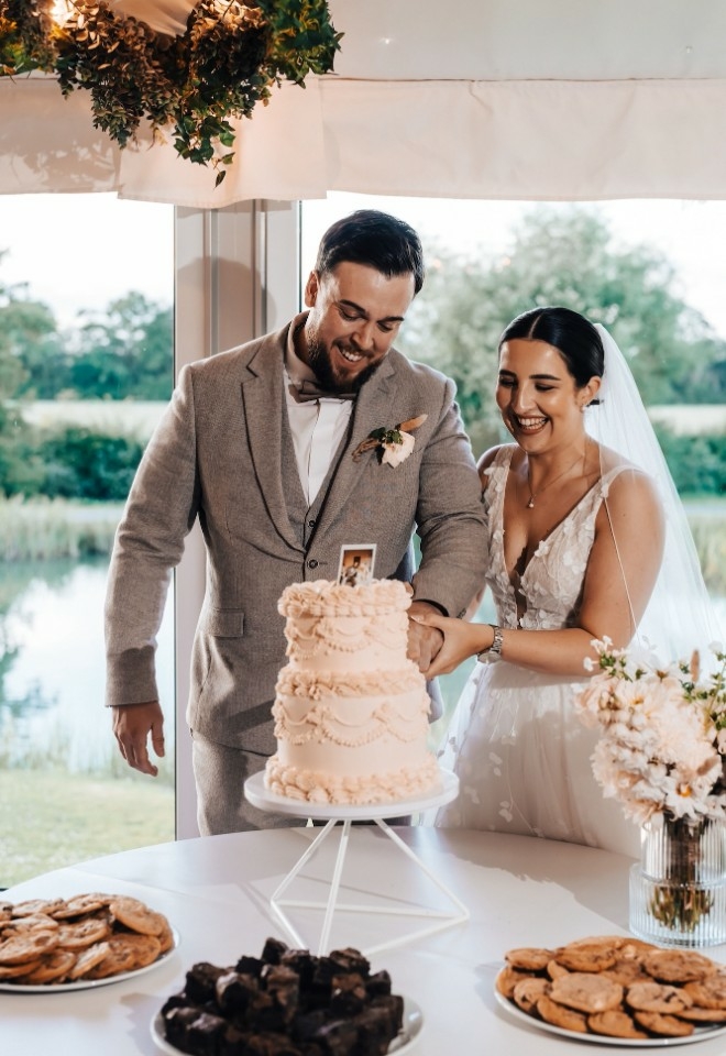 Sophie and Nathan cutting wedding cake