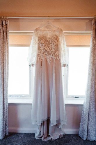 Wedding dress hanging on window sill 
