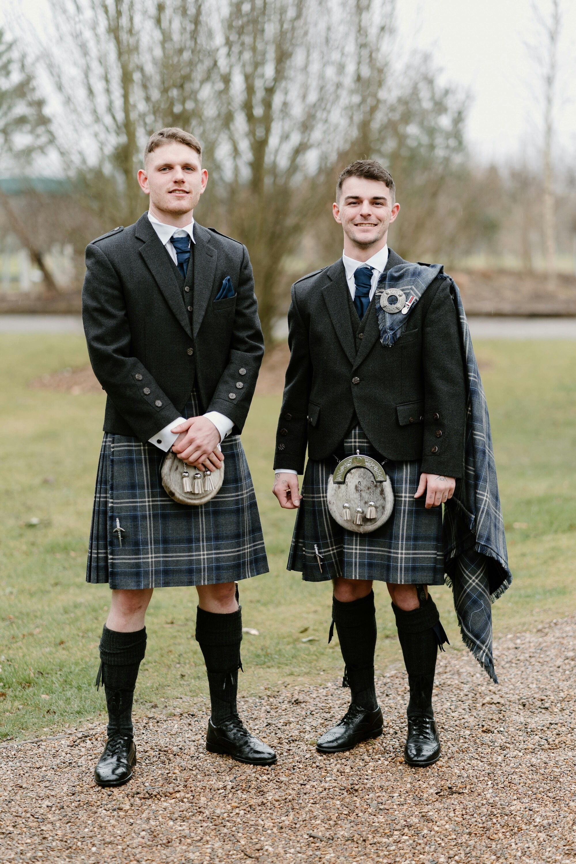 Groom and best man dressed in kilts and traditional scottish wedding attire