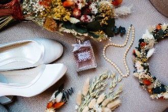 Shoes, perfume, jewellery and flowers for bride at wedding