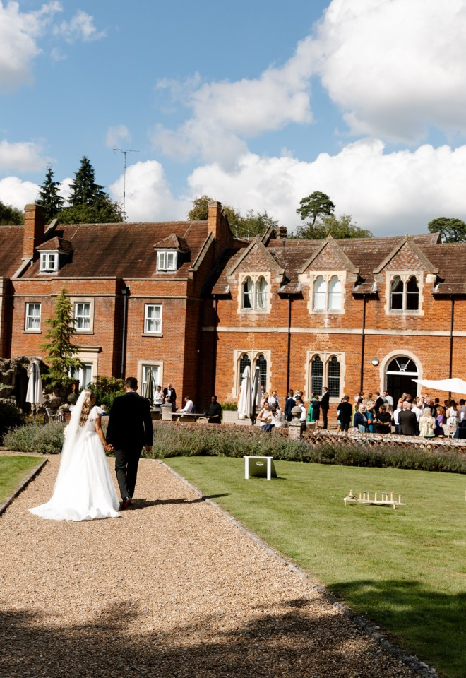 Bride and groom walk towards wedding guests