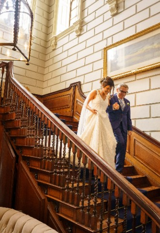 Ana and her father walking down the staircase at Davenport House