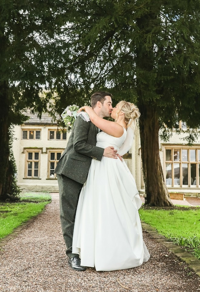 Bride and groom embracing outside of Mitton Hall