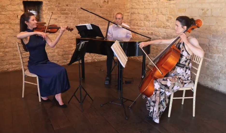 The Sorelli Ensemble preforming a piano, violin, and cello ensemble during a wedding ceremony