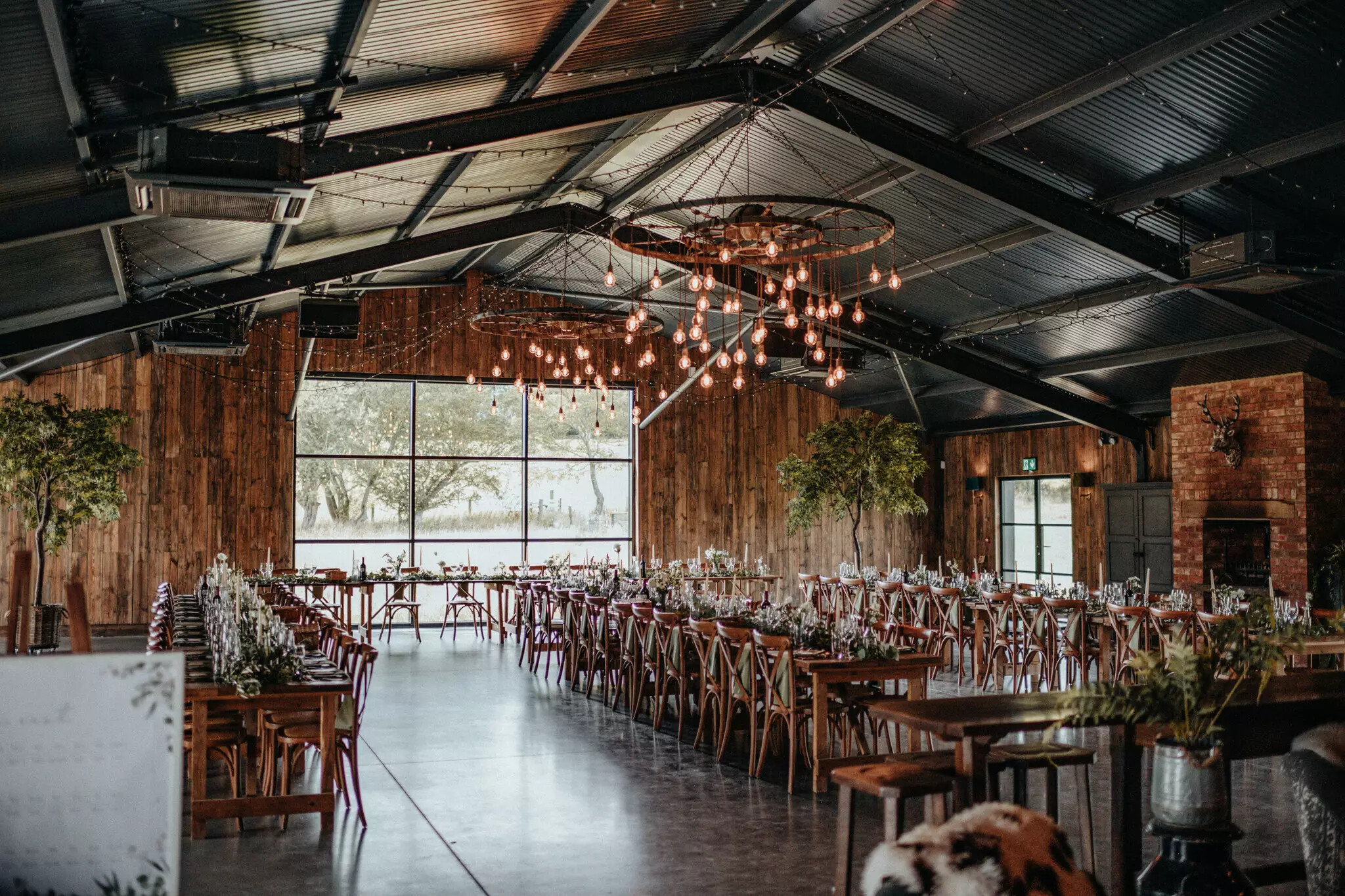 Wedding breakfast inside industrial style barn wedding venue in Hampshire, Silchester Farm