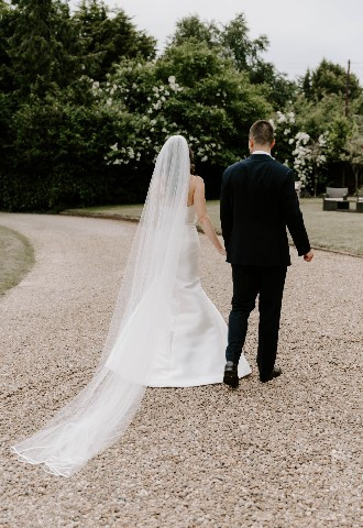Bride and groom walking through grounds at Glewstone Court