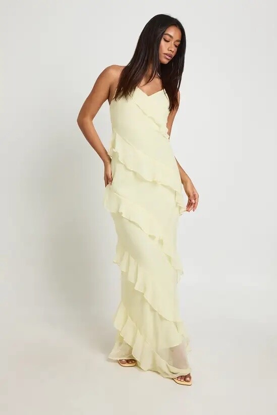 Teen bridesmaid wearing a pale lemon chiffon maxi dress with layered ruffle detailing and spaghetti straps.