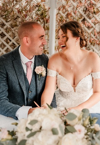 Wedding couple at ceremony signing document at Southdowns Manor West Sussex