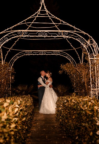 Wedding couple evening photo under wire arch at Southdowns Manor West Sussex