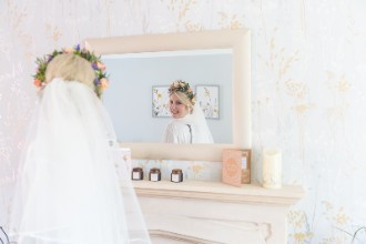 Hannah looking at her hair and veil in the mirror at home