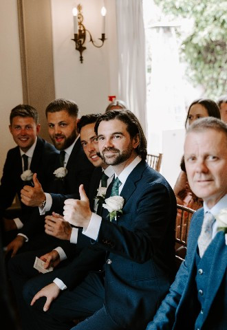 Groomsmen sat down at ceremony at Glewstone Court