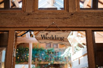 Wooden arrow wedding sign hanging in doorway 