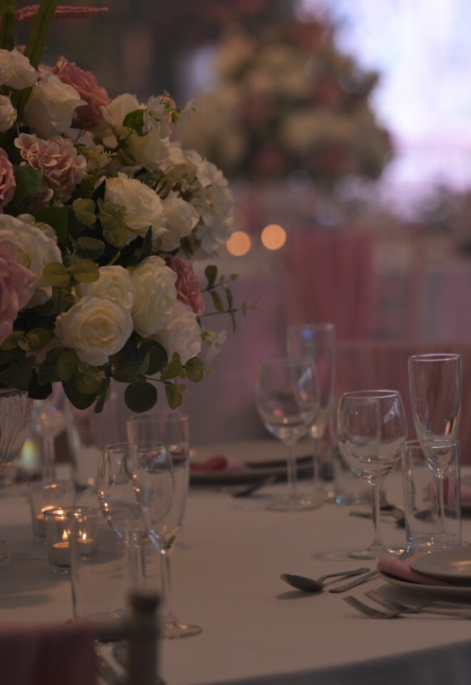 Pink and white flowers kept on a table designed and styled for a wedding reception